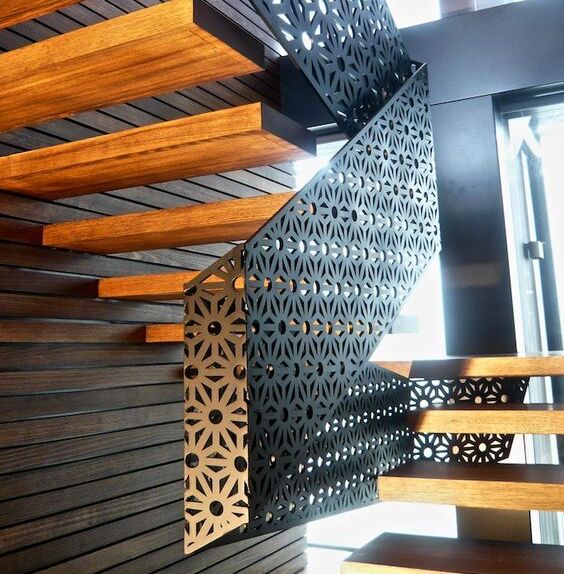 Habillage d’escalier en métal découpé laser, intégration décorative sur structure existante.
