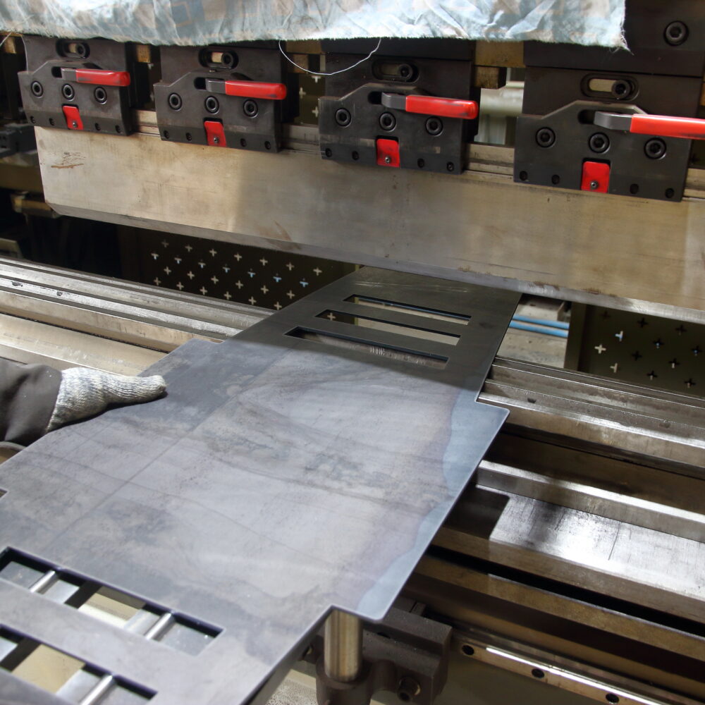 Opération de pliage sur presse plieuse dans un atelier de tôlerie industrielle en Île-de-France