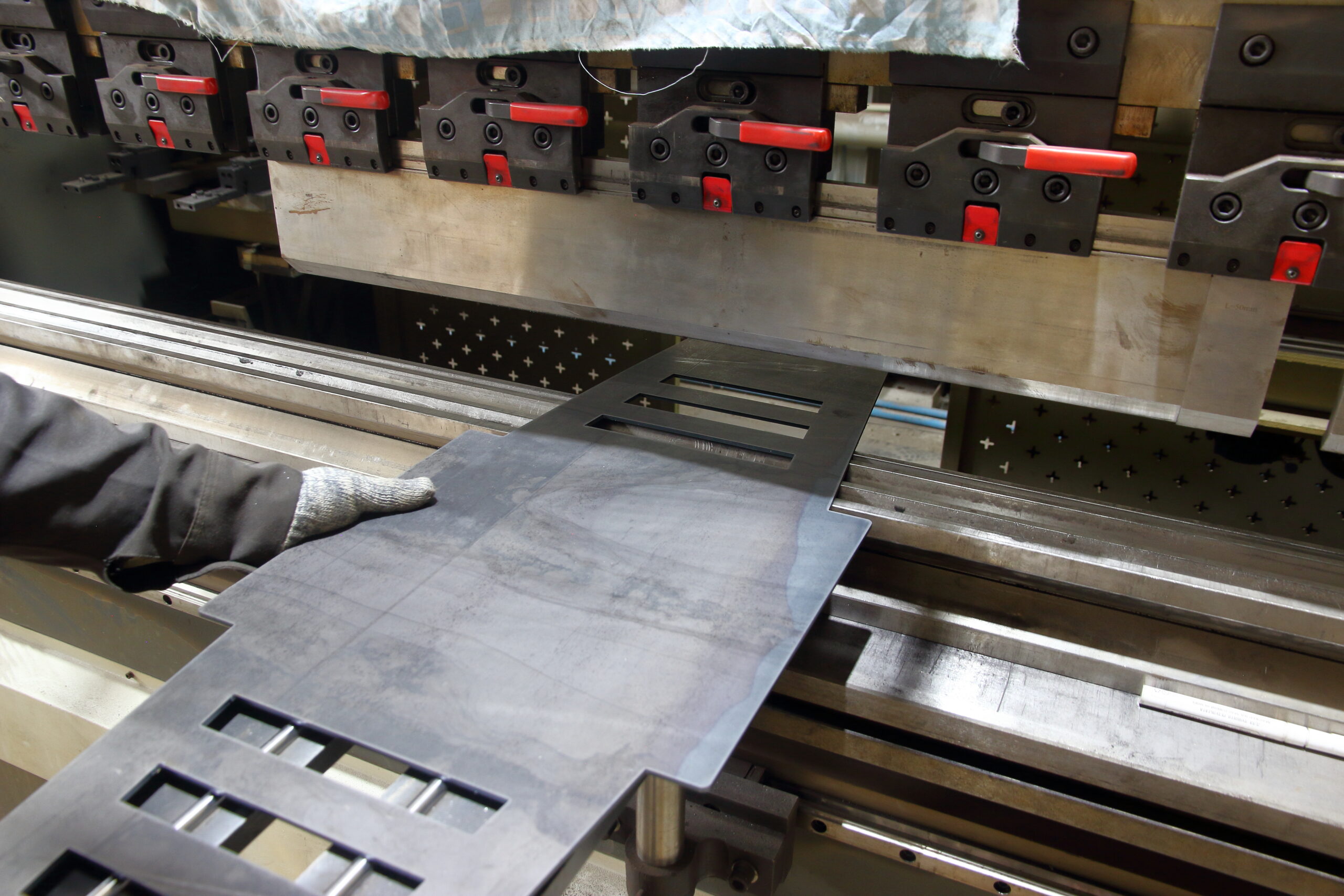 Opération de pliage sur presse plieuse dans un atelier de tôlerie industrielle en Île-de-France